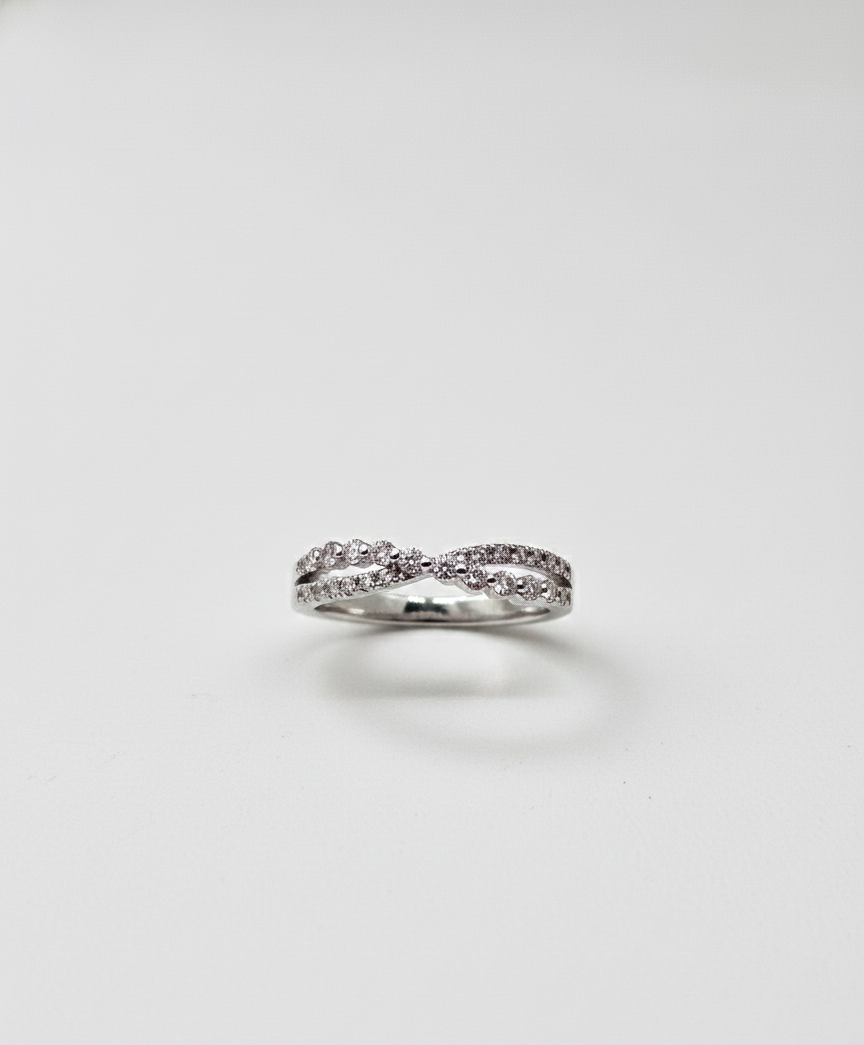 Silver ring with small diamonds on a light gray background