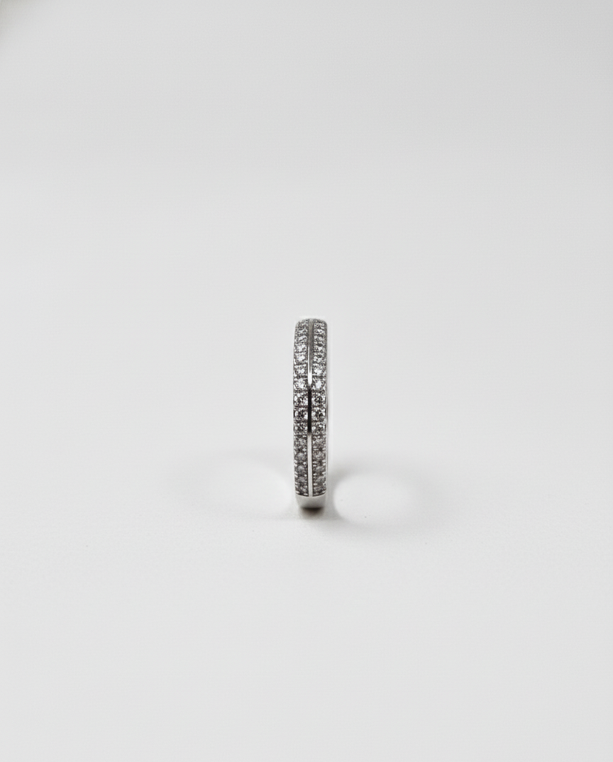 Silver ring with embedded stones on a light gray background