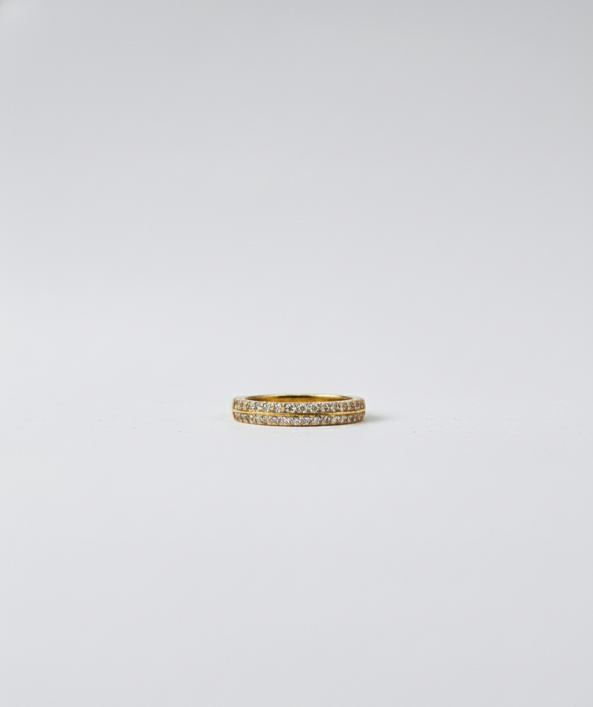 Gold ring with small diamonds on a light gray background