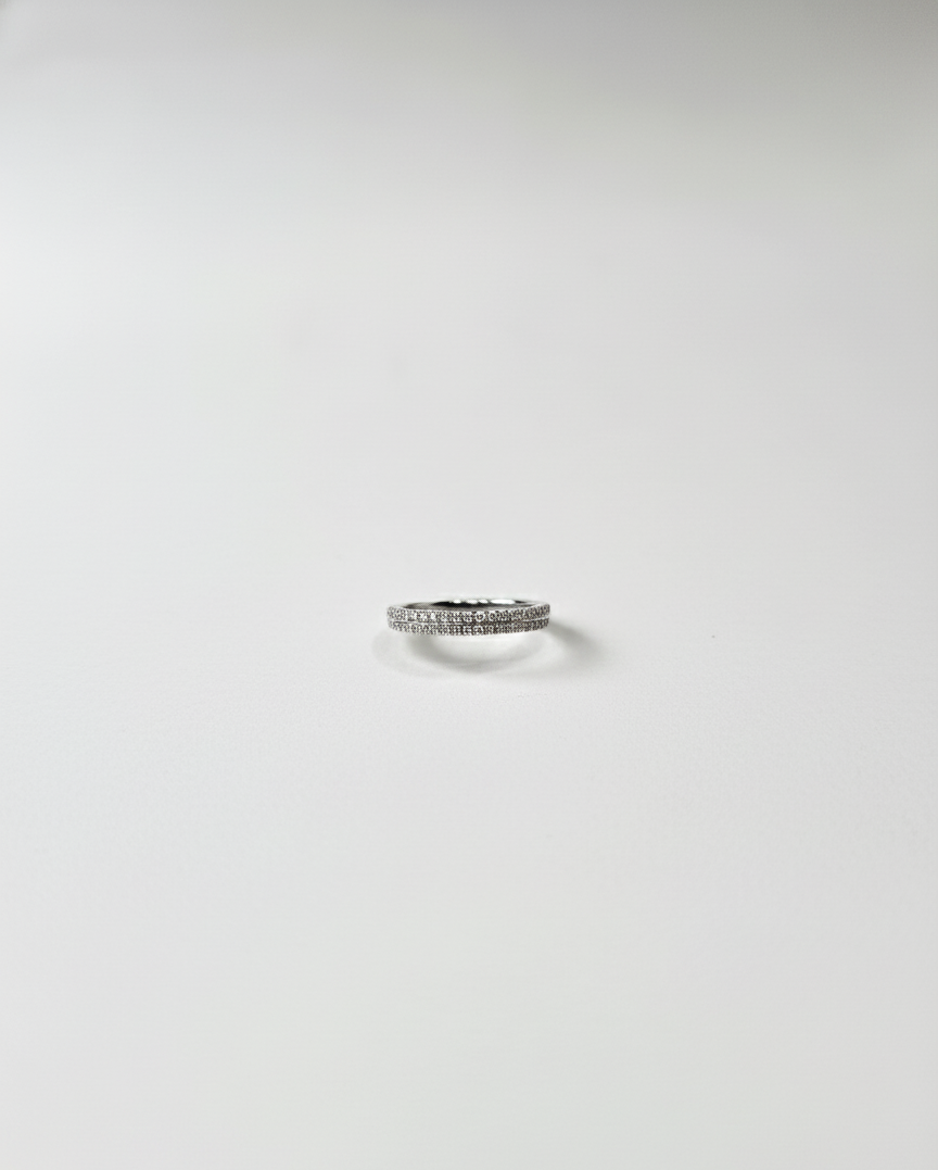 Silver ring with small stones on a light gray background